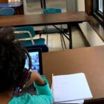Girl with headphones sitting in classroom